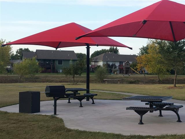 A red umbrella is opened in a park
